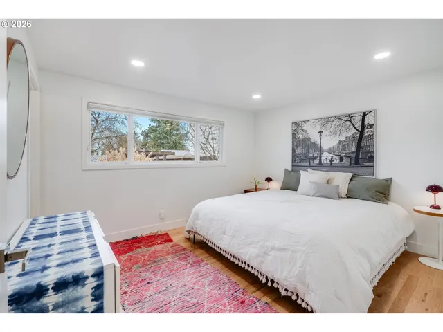 a bedroom with a bed and a painting on the wall