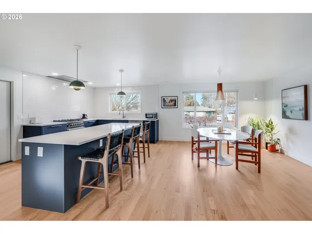 a dining room with stainless steel appliances kitchen island granite countertop a dining table chairs and granite counter tops
