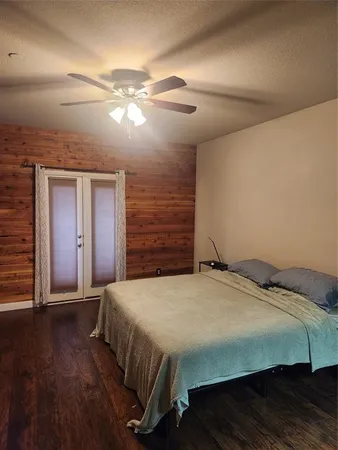 a bedroom with a bed and wooden floor