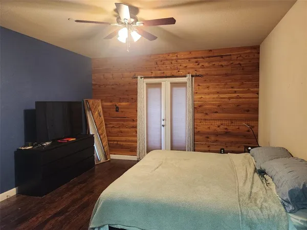 a bedroom with a bed and a flat tv screen on a dresser