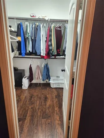 a view of walk in closet with clothes and shoes