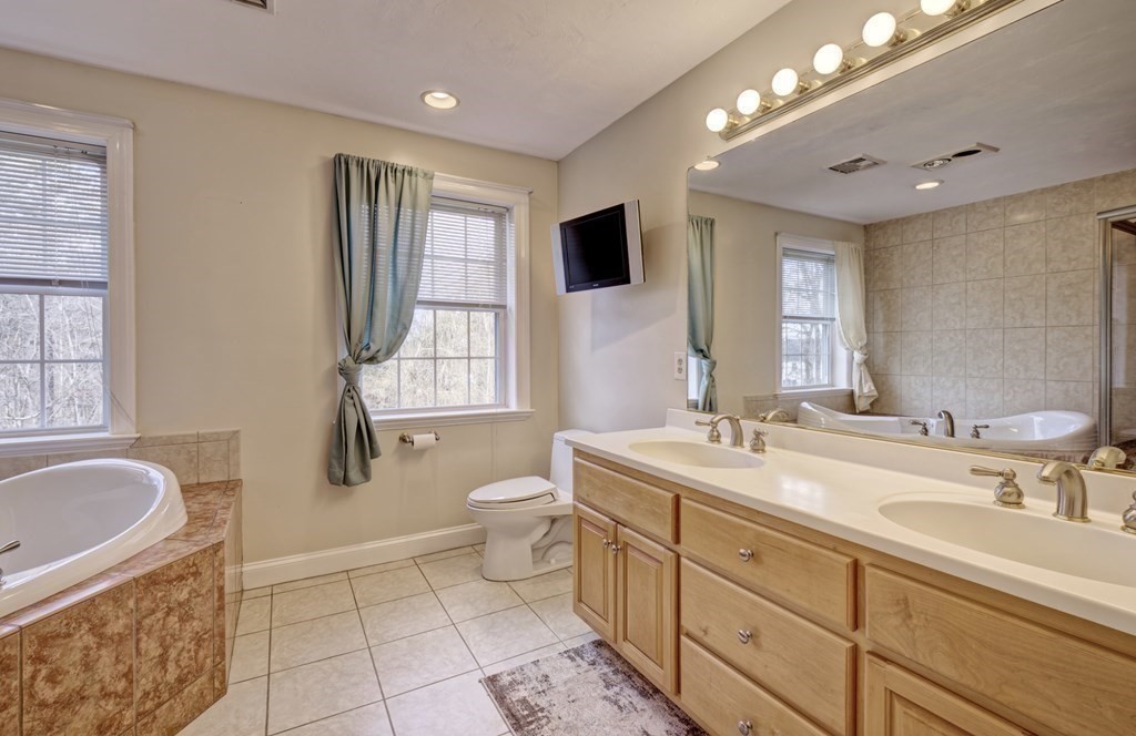 6 Elizabeth Road Auburn, MA 01501 - Photo 25 of 41 a bathroom with a granite countertop sink mirror vanity bathtub and a toilet