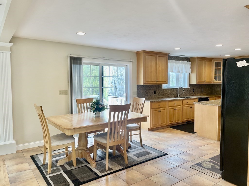 6 Elizabeth Road Auburn, MA 01501 - Photo 10 of 41 a kitchen with granite countertop a stove a sink a dining table and chairs
