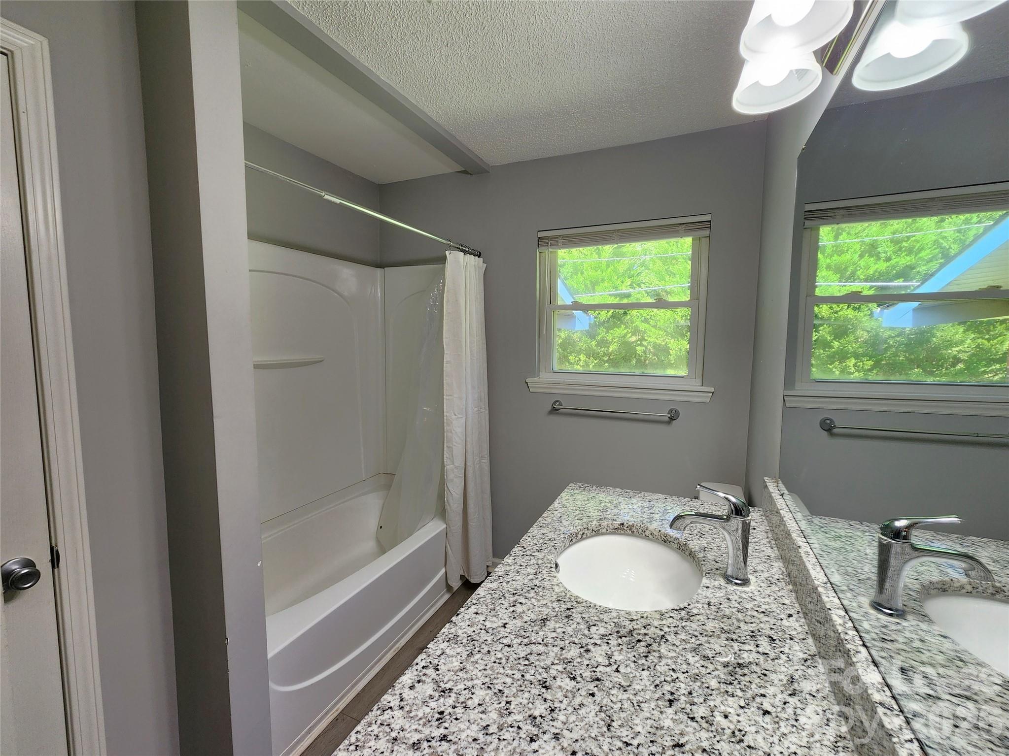 4633 Club View Drive Concord, NC 28025 - Photo 11 of 16 a bathroom with a granite countertop sink a mirror and a bathtub