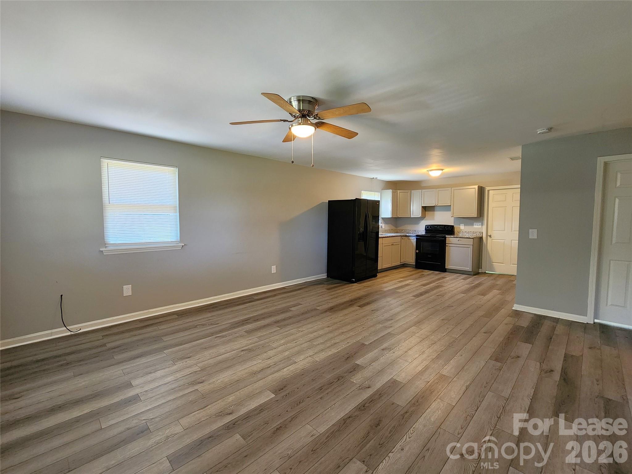 4633 Club View Drive Concord, NC 28025 - Photo 2 of 16 a view of a kitchen with a stove a refrigerator a ceiling fan and wooden floor