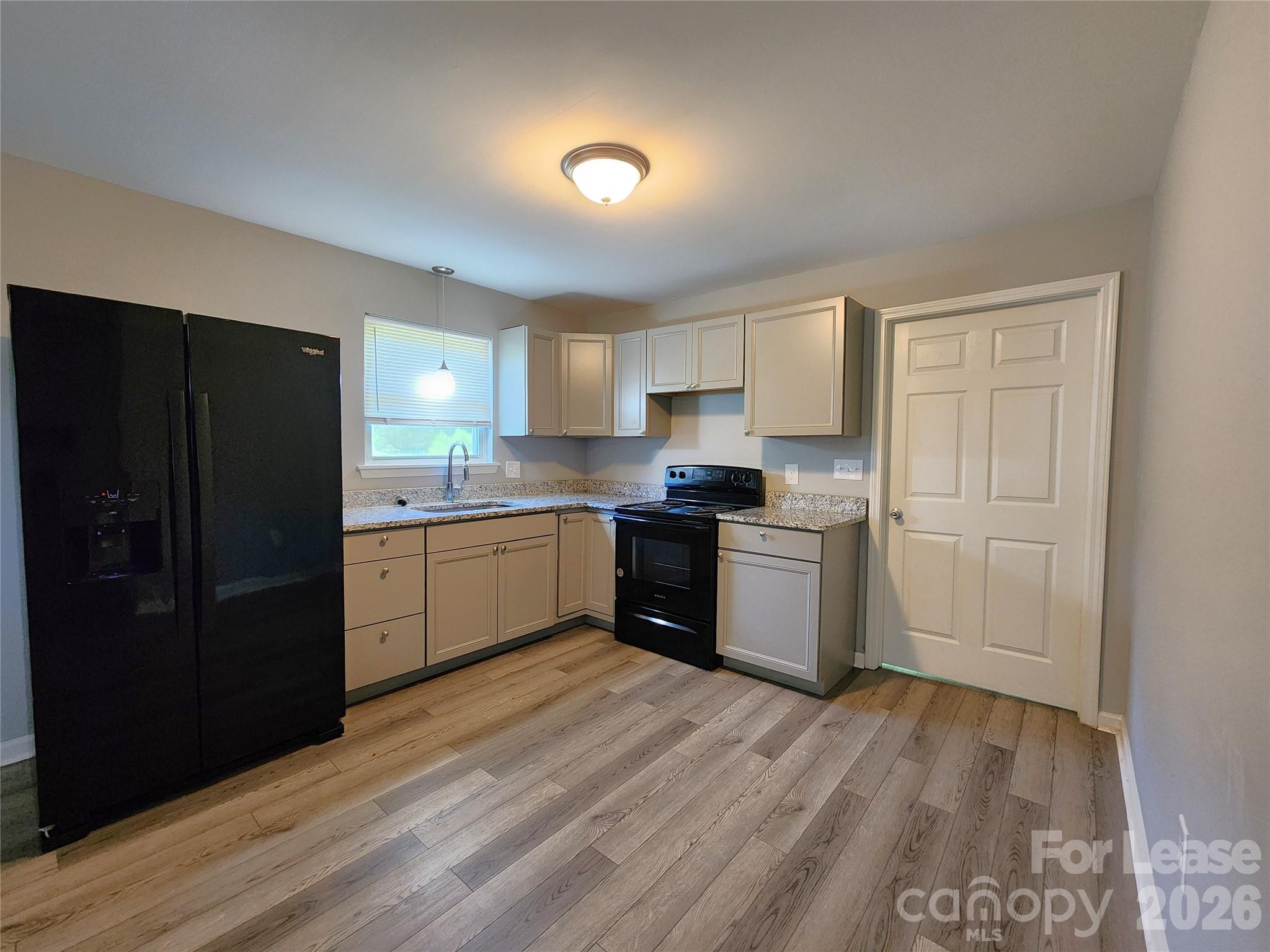 4633 Club View Drive Concord, NC 28025 - Photo 4 of 16 a kitchen with a refrigerator a sink and cabinets