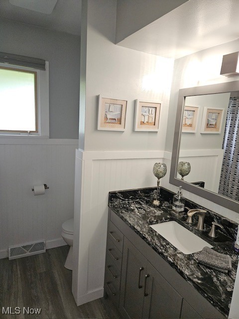 3084 Killian Road Uniontown, OH 44685 - Photo 22 of 38 Bathroom featuring toilet, laminate floors, a wainscoted wall, and vanity