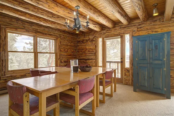 a dining room with furniture and a floor to ceiling window