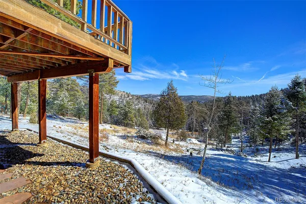 a view of a house with a cars park side of a road