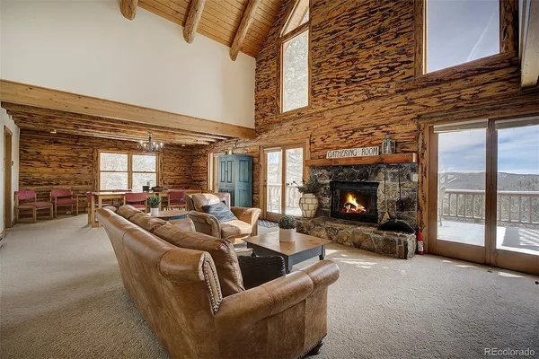 a living room with furniture a fireplace and a large window