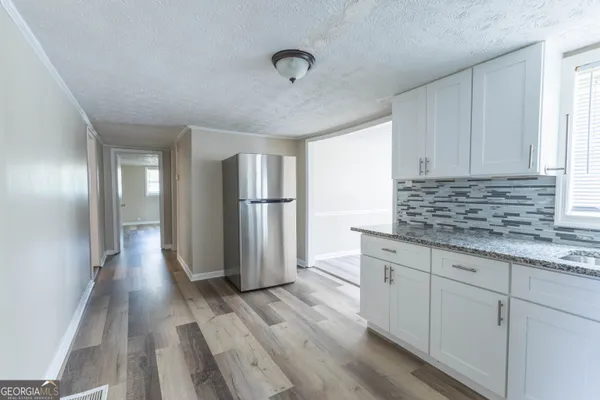 a kitchen with granite countertop a refrigerator and a sink