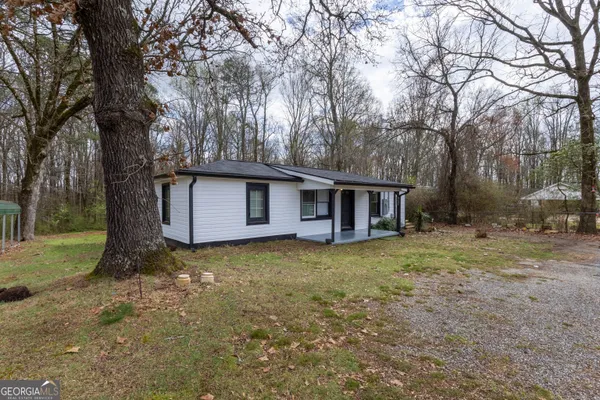 a view of a house with backyard and trees