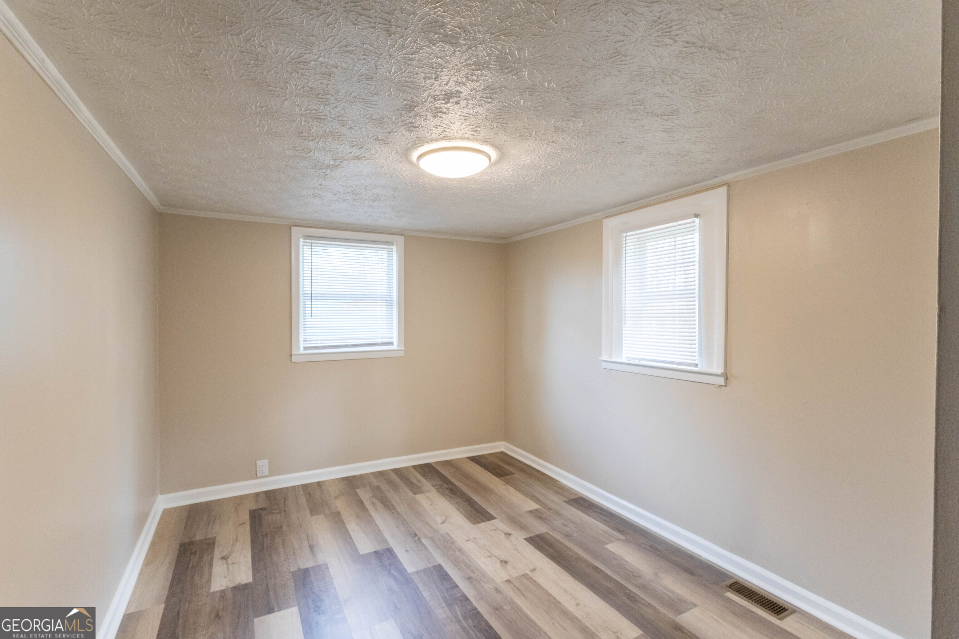 5326 Heardsville Road Cumming, GA 30028 - Photo 8 of 22 an empty room with wooden floor and windows