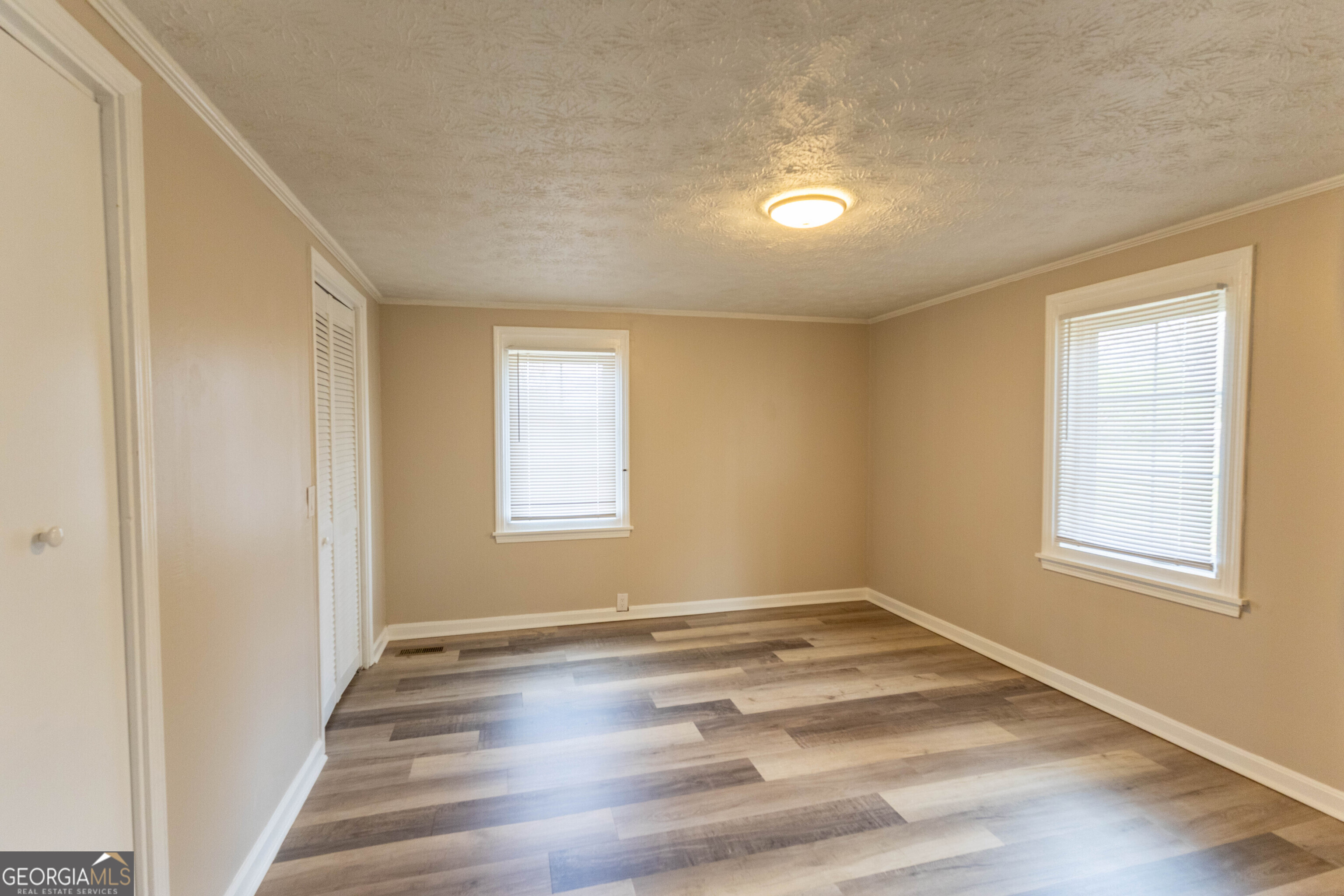 5326 Heardsville Road Cumming, GA 30028 - Photo 9 of 22 an empty room with wooden floor and windows
