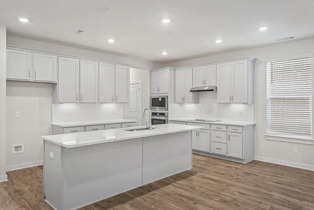 a kitchen with white cabinets appliances and sink