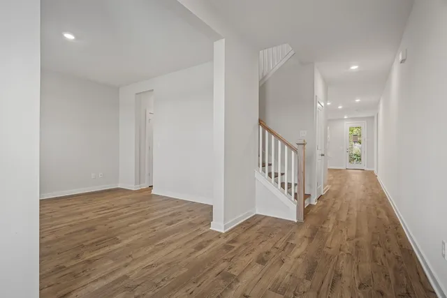 a view of a hallway with wooden floor and staircase