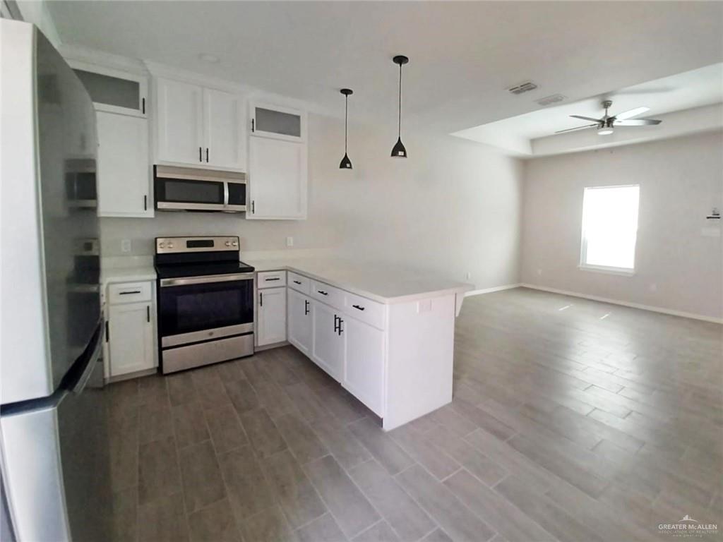 1506 Playa Drive, Unit 4 Weslaco, TX 78596 - Photo 4 of 14 a kitchen with stainless steel appliances granite countertop a stove a sink and a refrigerator