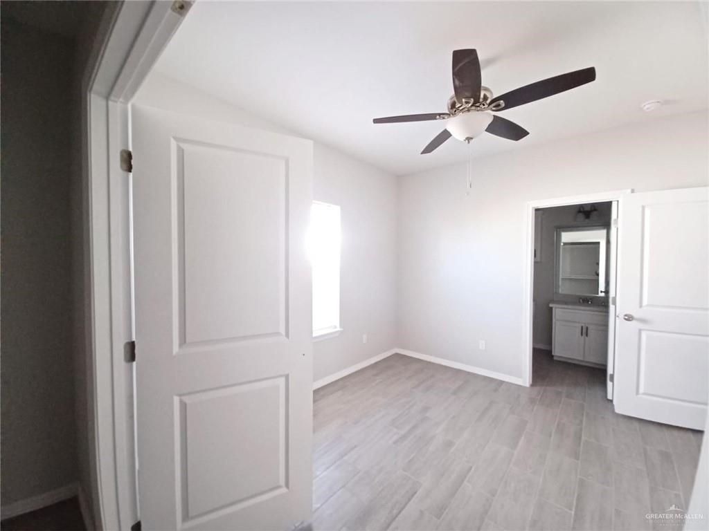 1506 Playa Drive, Unit 4 Weslaco, TX 78596 - Photo 8 of 14 an empty room with wooden floor closet and windows