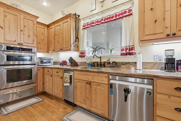 a kitchen with granite countertop cabinets stainless steel appliances and wooden floor