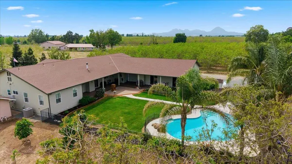 a front view of a house with a garden and yard