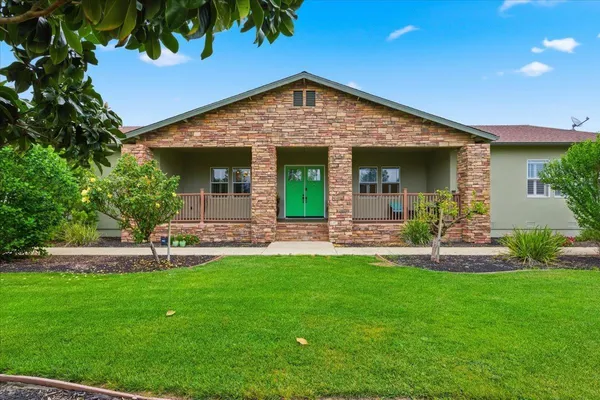 a view of a house with a yard and potted plants