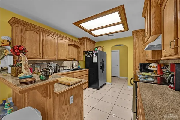 a kitchen with stainless steel appliances granite countertop a refrigerator and a stove