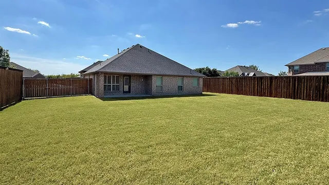 a view of a house with a yard and a fence