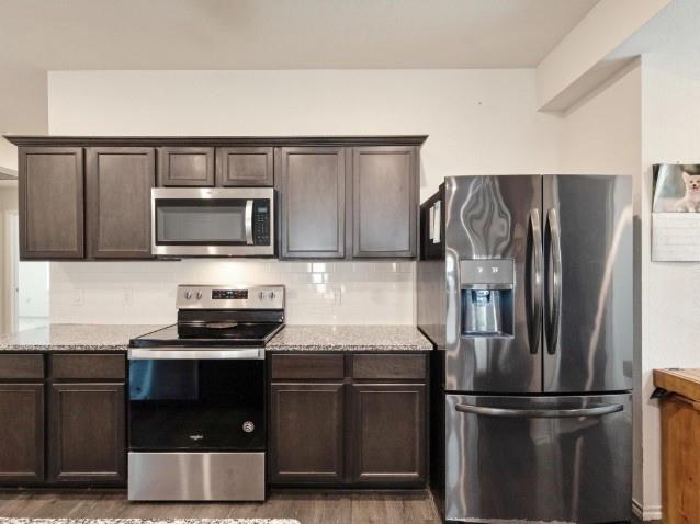 1223 Trevino Road Forney, TX 75126 - Photo 3 of 20 a kitchen with a refrigerator and a stove top oven