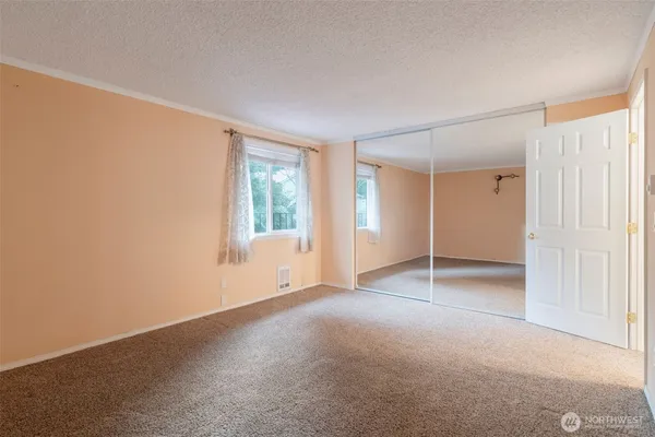 an empty room with windows and closet