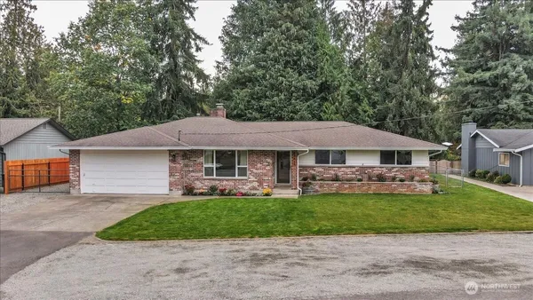 a front view of a house with a garden and trees