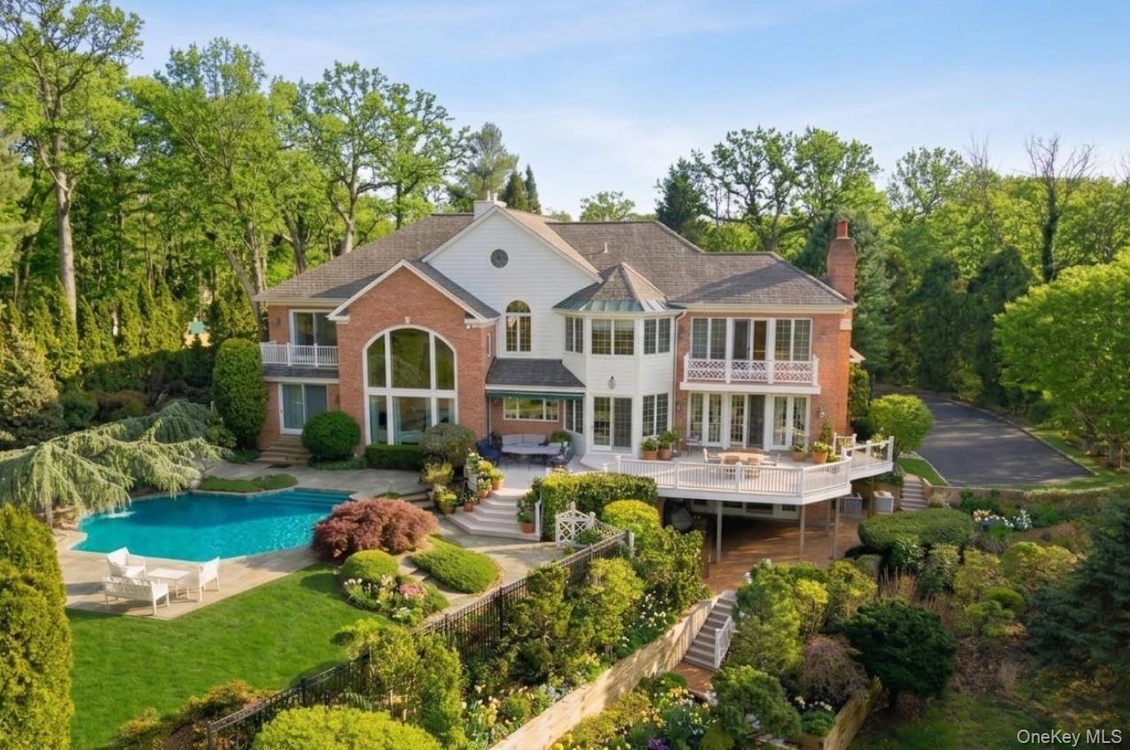 a front view of a house with garden and trees