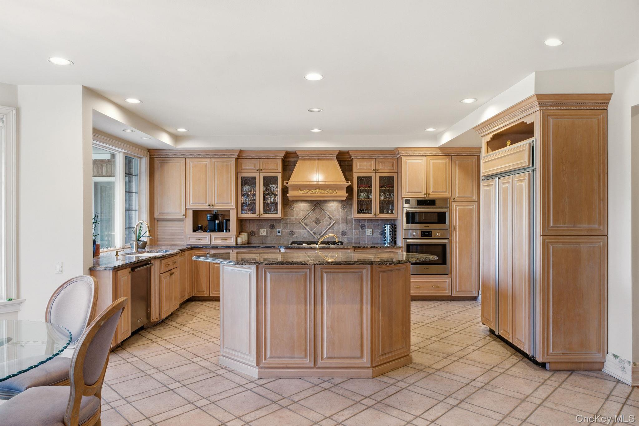 19 Cobblestone Court Centerport, NY 11721 - Photo 20 of 45 a kitchen with stainless steel appliances granite countertop a sink and a refrigerator