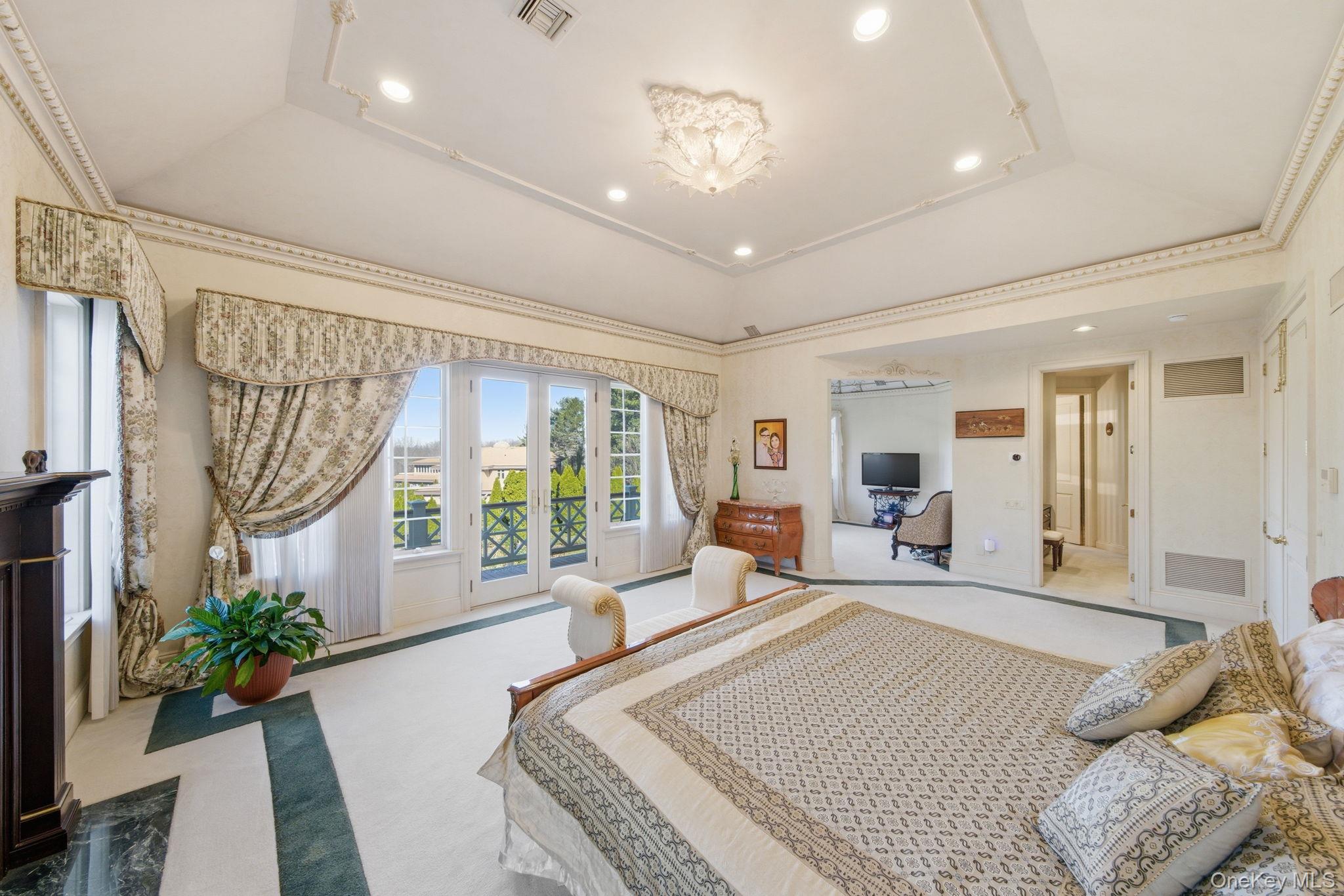 19 Cobblestone Court Centerport, NY 11721 - Photo 28 of 45 a spacious bedroom with a large bed and a large window with wooden floor