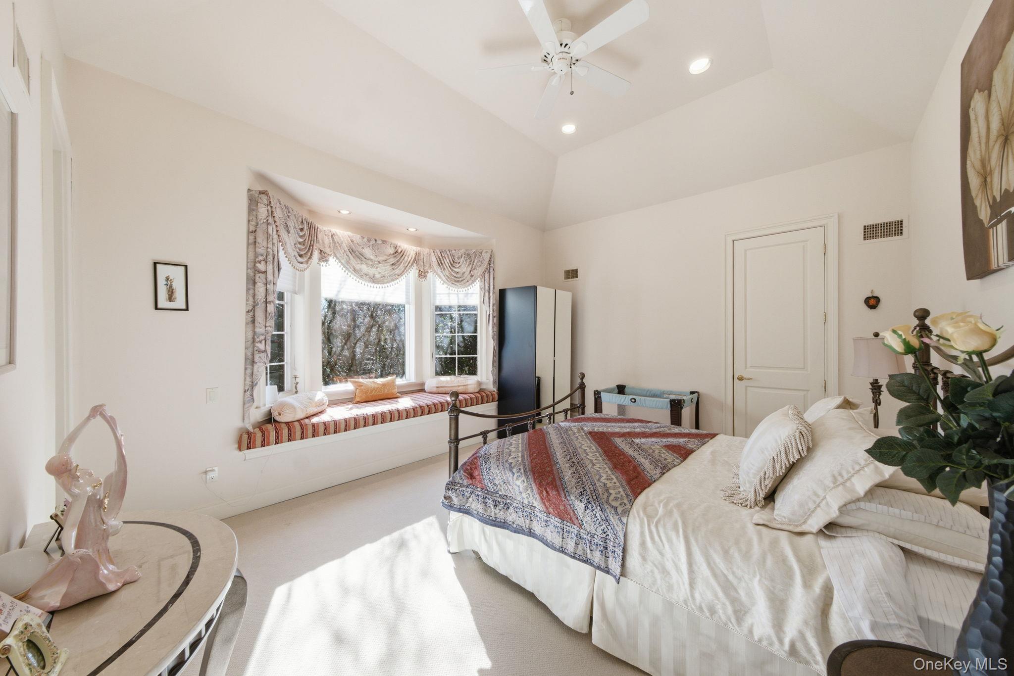 19 Cobblestone Court Centerport, NY 11721 - Photo 31 of 45 a spacious bedroom with a bed and large windows