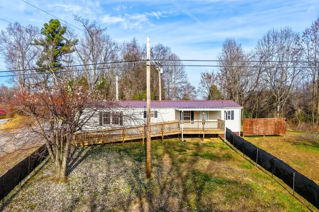 a view of a swimming pool with a patio and a yard