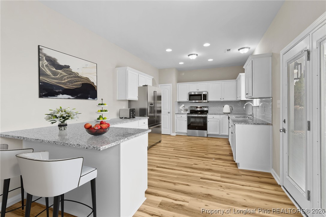 288 New Castle Lane Spring Lake, NC 28390 - Photo 14 of 39 a kitchen with kitchen island a sink stainless steel appliances and cabinets