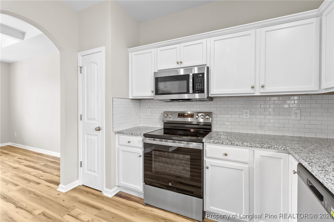 288 New Castle Lane Spring Lake, NC 28390 - Photo 16 of 39 a kitchen with granite countertop white cabinets and stainless steel appliances