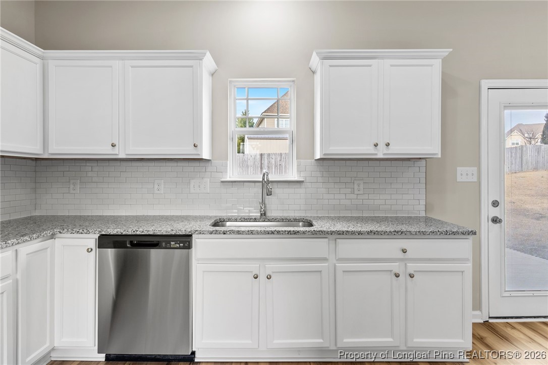 288 New Castle Lane Spring Lake, NC 28390 - Photo 17 of 39 a kitchen with granite countertop white cabinets and a sink