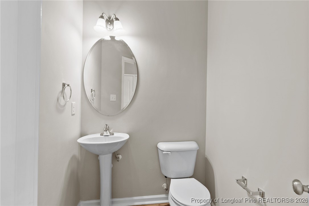288 New Castle Lane Spring Lake, NC 28390 - Photo 9 of 39 a bathroom with a toilet sink and mirror