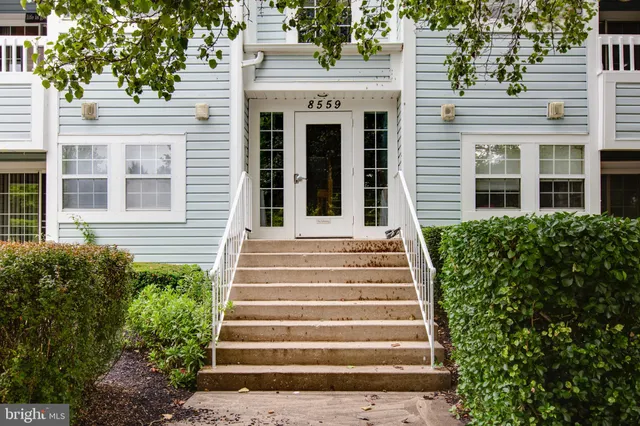 a view of a house with potted plants and a table and chairs