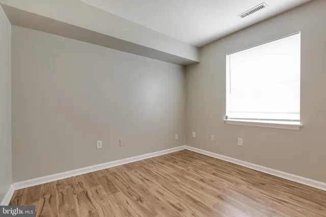 wooden floor in an empty room with a window