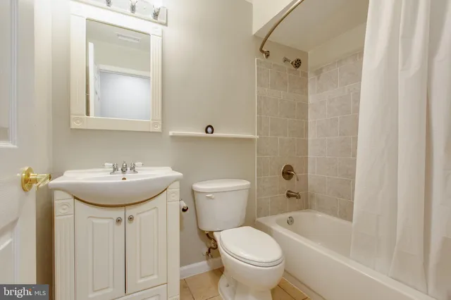a bathroom with a bathtub shower sink mirror and toilet