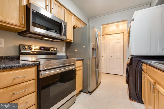 a kitchen with stainless steel appliances granite countertop a stove a microwave and a refrigerator
