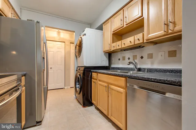 a kitchen with stainless steel appliances granite countertop a refrigerator and a stove