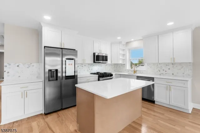 a kitchen with stainless steel appliances a refrigerator sink and microwave