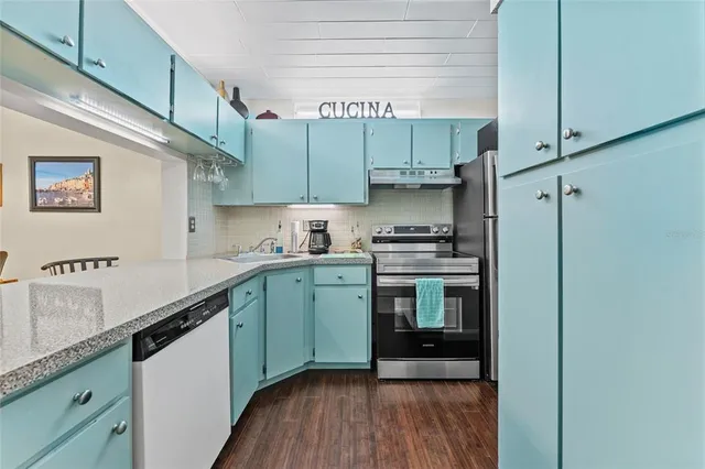 a kitchen with a sink a refrigerator and cabinets