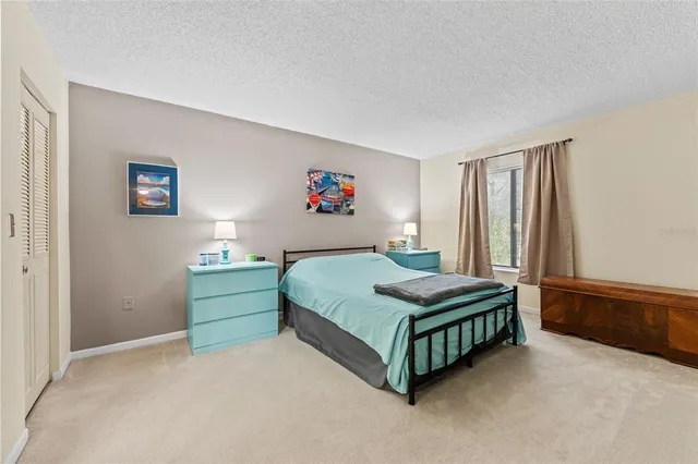 a room with a bed dresser and window