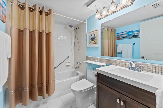 a bathroom with a sink a toilet a mirror and shower