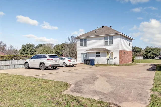 a view of a white house in middle of the road