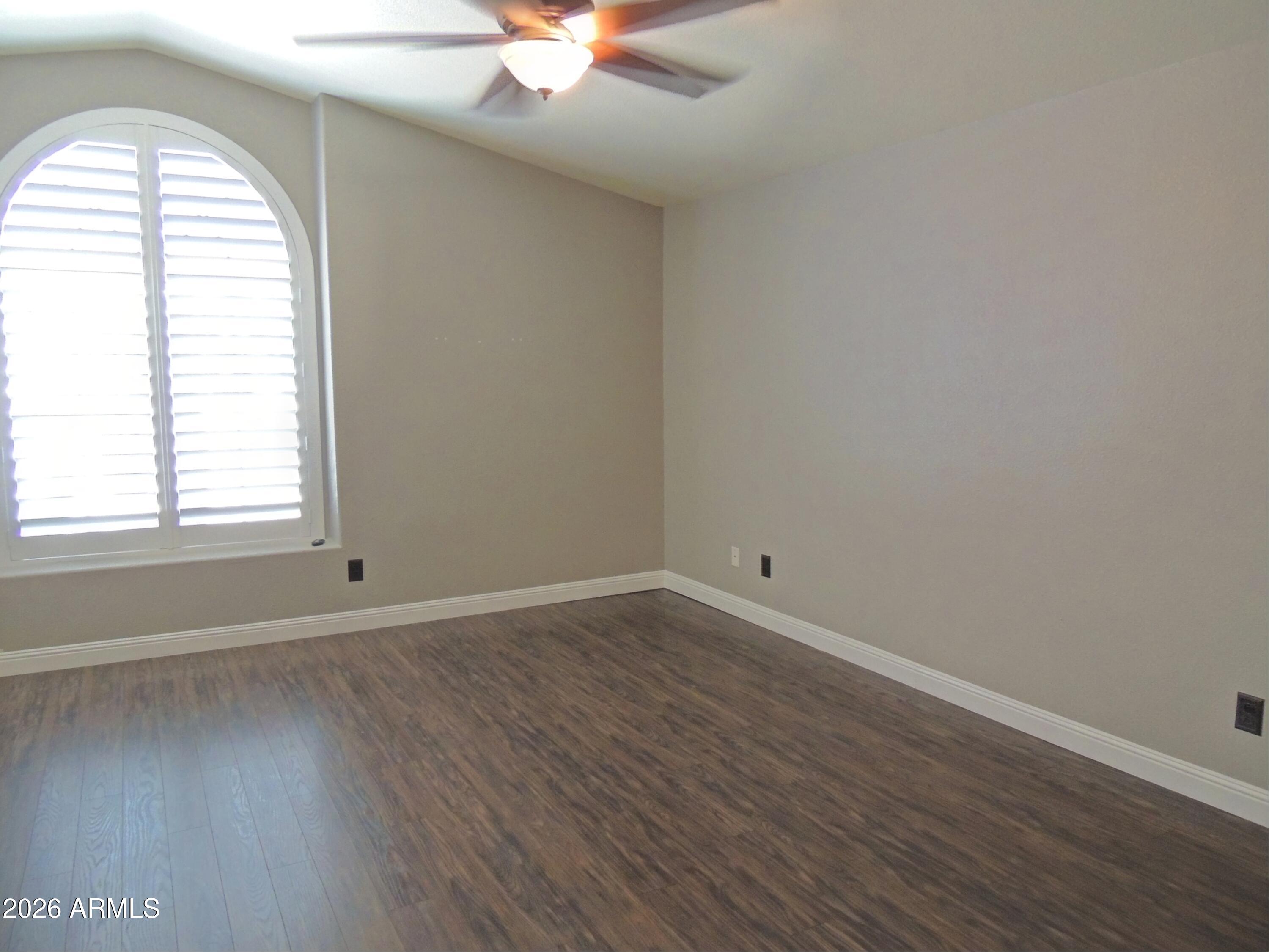 4409 East Dry Creek Road Phoenix, AZ 85044 - Photo 15 of 34 an empty room with wooden floor and windows